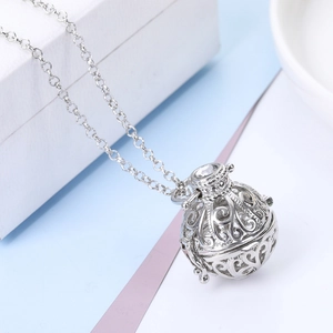 Detailed macro view of an openable silver hollow cage pendant with intricate floral patterns