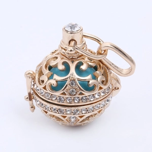 Pendente dorato traforato con perla blu e cristalli su collana elegante