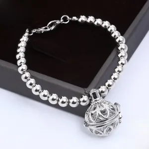 Detail of silver beaded bracelet with hollow filigree aromatherapy locket and colorful felt balls