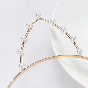 Close-up of golden cat ear headband with elegant white pearls on a white porcelain plate