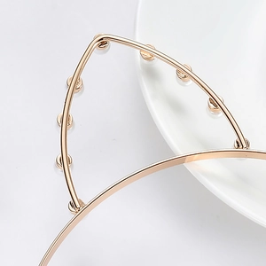 Golden cat ear headband with pearl accents on a minimalist white ceramic tray