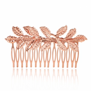Rose gold leaf bridal hair comb with intricate nature design on a reflective white base
