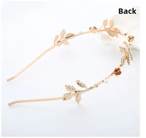 Detail view of golden metal headband featuring delicate rose petals and leaf ornaments