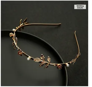 Macro detail of golden metal roses, leaf textures, and small pearls on the headband
