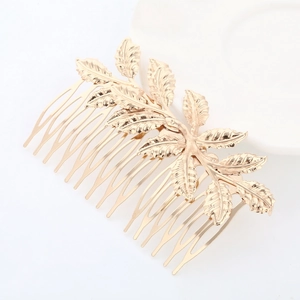 Detailed view of golden leaf hair comb with textured branch design for bridal hairstyle