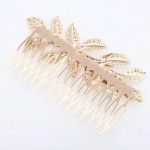 Detailed close-up of golden metal leaf hair comb accessory for bridal hairstyles