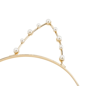 Detailed view of golden cat ear headband with white pearls and slim metal frame