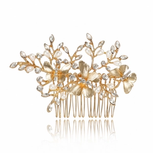 Detail of golden bridal hair comb with crystal butterflies and pearls on white background
