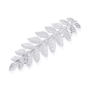 Détail d'une pince à cheveux feuille argentée avec texture métallique et motif botanique