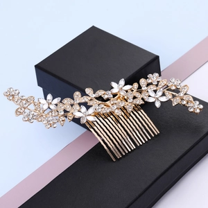 Macro shot of gold bridal hair comb with white acrylic petals and crystals