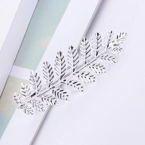 Détail macro de la pince à cheveux en feuille d'argent poli avec texture métallique