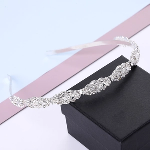 Close-up of silver bridal headband with leaf-shaped rhinestones on a jewelry box