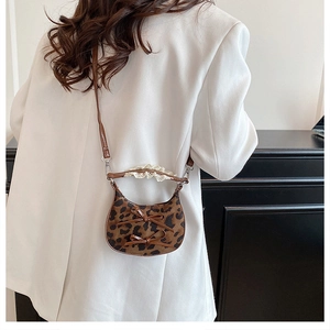 Mini leopard print saddle bag with bow details and lace handle shown on a model