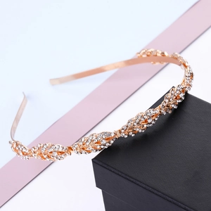 Macro detail of a gold rhinestone bridal headband with sparkling leaf pattern on box
