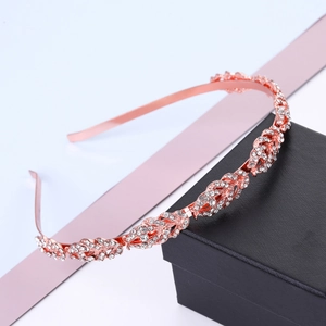 Fashion rose gold leaf headband with rhinestones displayed on a gift box background