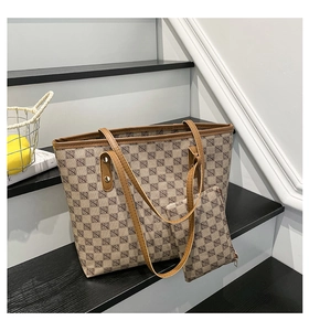Detail of a large beige tote bag set with geometric logo print on premium leather