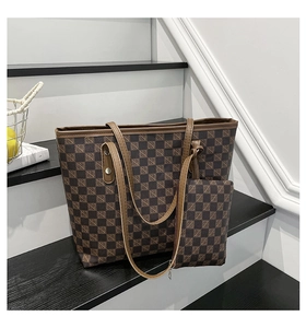Detail shot of brown checkerboard tote with matching zipper pouch and leather straps