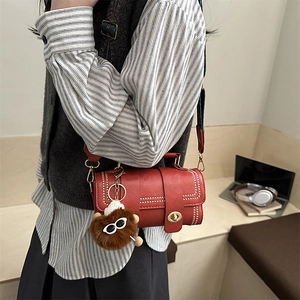 Vintage red pillow shoulder bag for women with plush bear charm and patterned strap