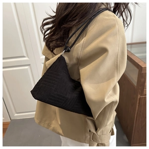 Detail of black tote bag with geometric embossed texture and silver zipper for women