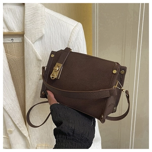 Detailed view of the dark brown matte leather bag with golden rectangular turn-lock
