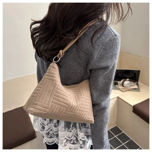 Detail of light beige tote bag with geometric embossed texture and knot shoulder strap