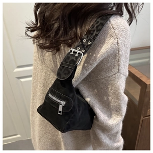 Detail of black hobo bag with eyelet wide strap and leopard jacquard texture