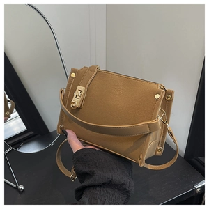 Detail of camel leather textured crossbody bag with vintage gold metal buckle and studs