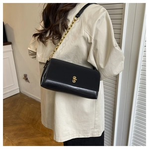 Detail der schwarzen quadratischen Ledertasche mit goldener Metallkette und PU-Finish