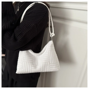 Close-up of white woven shoulder bag texture with knot detail and crescent shape