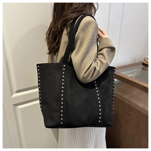 Detail of vintage black suede tote bag with silver rivet studs and large capacity