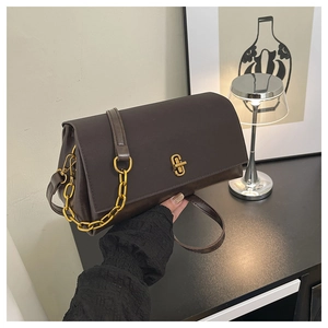 Detailed macro of vintage brown saddle bag with gold metal lock and chunky chain strap