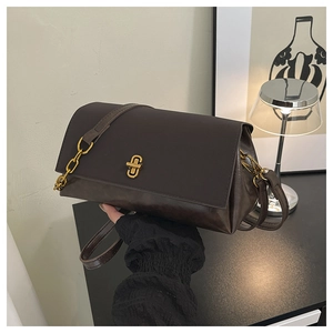 Close-up of dark brown leather crossbody bag with distinctive gold H-shaped twist lock