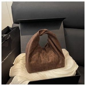Nahaufnahme braune Handtasche mit Leopardenmuster und Knotengriff in edler Geschenkbox