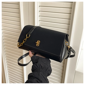 Detail of classic black shoulder bag with vintage gold twist lock and metal chain strap