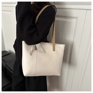 Minimalist cream tote bag with contrast brown handle and decorative scarf on model