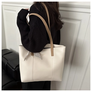Detail of cream white tote bag with printed silk scarf on brown strap and logo