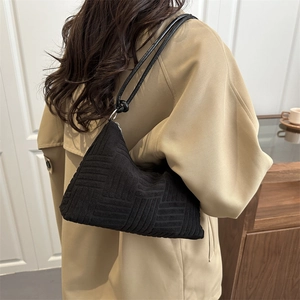 Minimalist black tote bag with geometric texture and asymmetrical triangular design