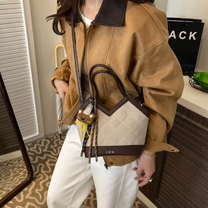 Retro quilted bucket bag with bear charm and tassel displayed on a female model crossbody
