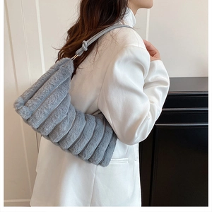 Détail du sac bandoulière en peluche grise avec rayures et sangle à nœuds décoratifs
