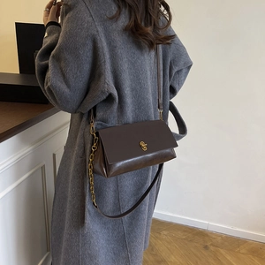 Minimalist deep brown matte leather crossbody bag with gold chain strap for winter 2025