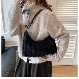 Détail du sac à bandoulière en peluche côtelée noire avec bandoulière en cuir et boucle