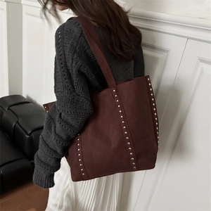 Retro burgundy suede tote bag with silver rivets shown from a side perspective