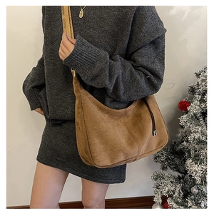 Detail of caramel suede hobo bag with wide strap in a cozy winter setting