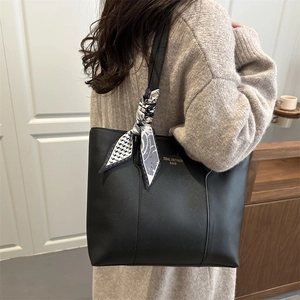 Minimalist black tote bag with silk scarf detail and golden logo for women