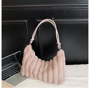 Détail du sac hobo en peluche rose clair avec texture plissée et bandoulière tressée
