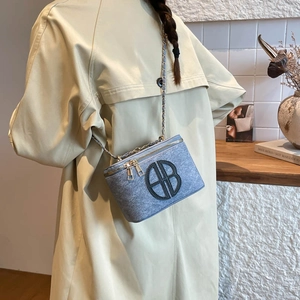 Light blue textured mini box crossbody bag with silver chain strap and metal logo detail