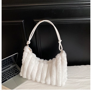 Détail du sac à épaule en fausse fourrure blanche avec plis verticaux et anse nouée