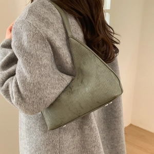 Vintage green curved shoulder bag with vertical texture and silver metal feet detail