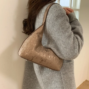 Metallic bronze hobo shoulder bag with pleated texture shown on a female model
