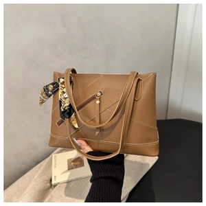 Brown faux leather tote bag detail with white contrast stitching and floral silk scarf charm